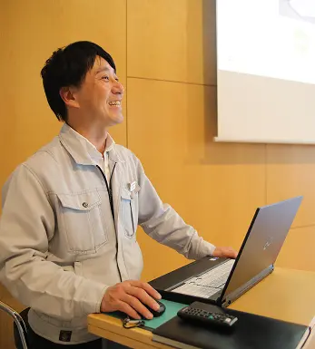 パソコンの前にいる男性の画像